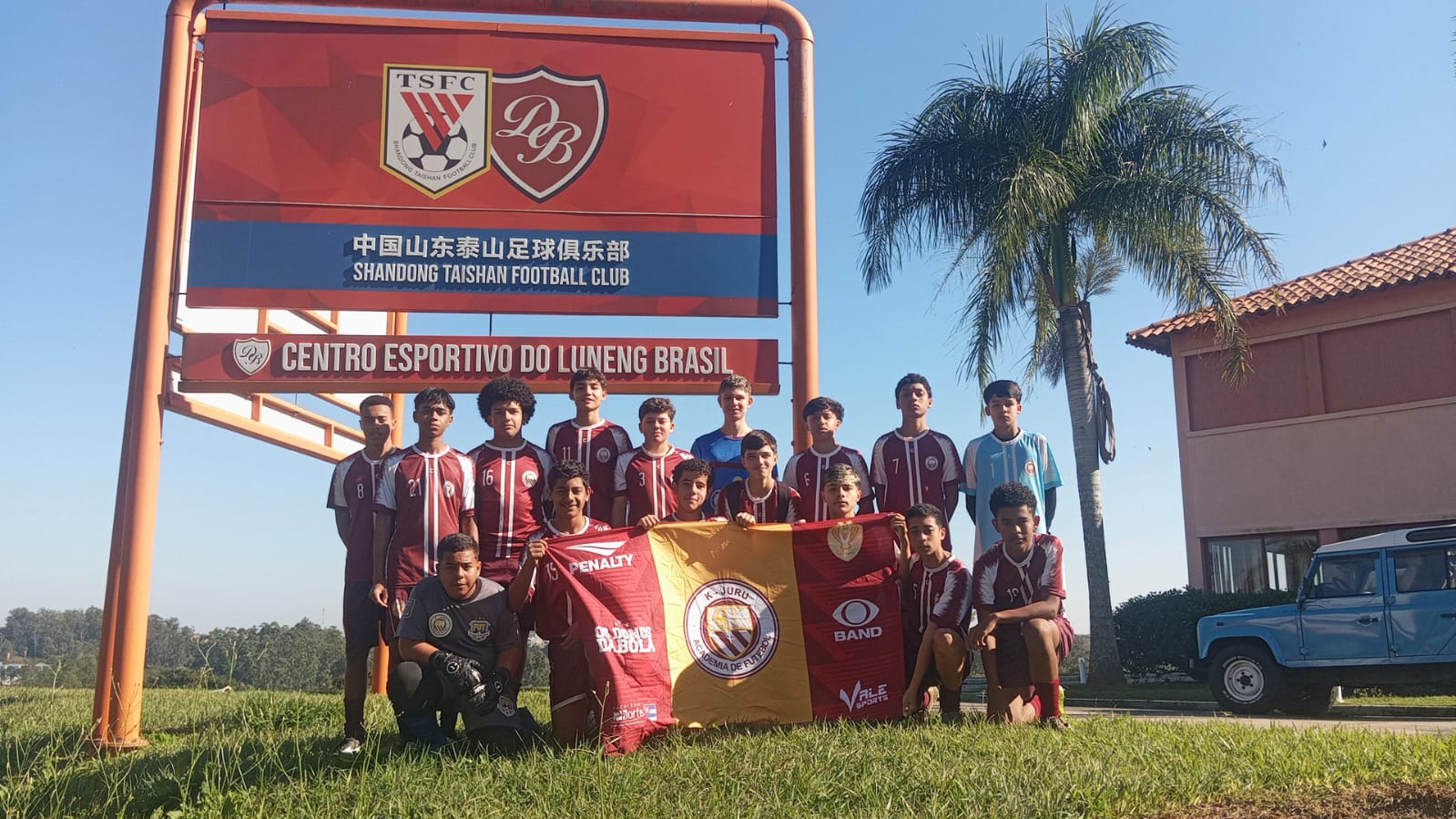 Equipe da K-Juru em frente ao letreiro do Centro Esportivo do Luneng Brasil durante a avaliação do Clube Desportivo Brasil