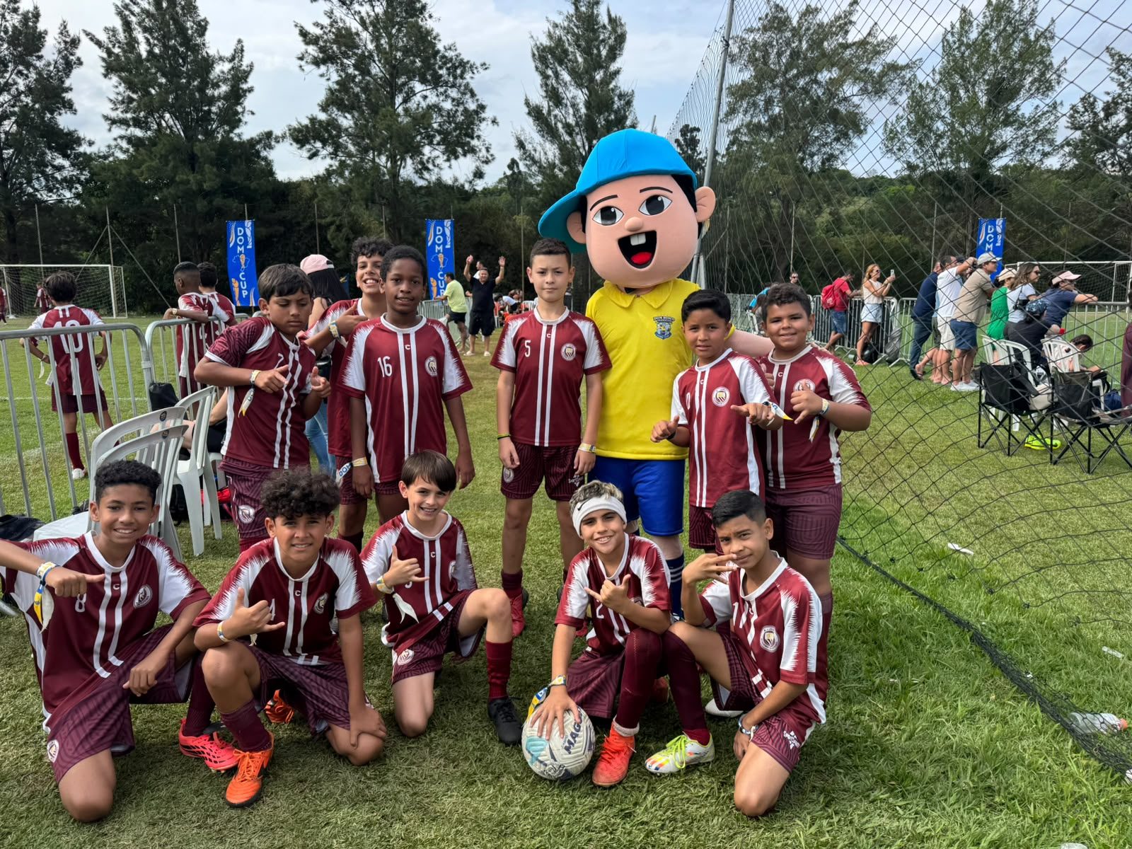 Atletas com o mascote do torneio no gramado