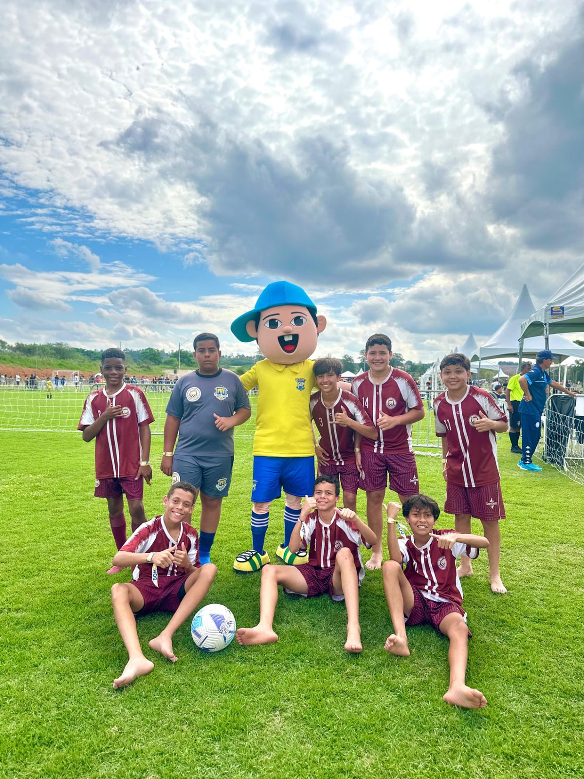 Registro da equipe com o mascote à beira do campo